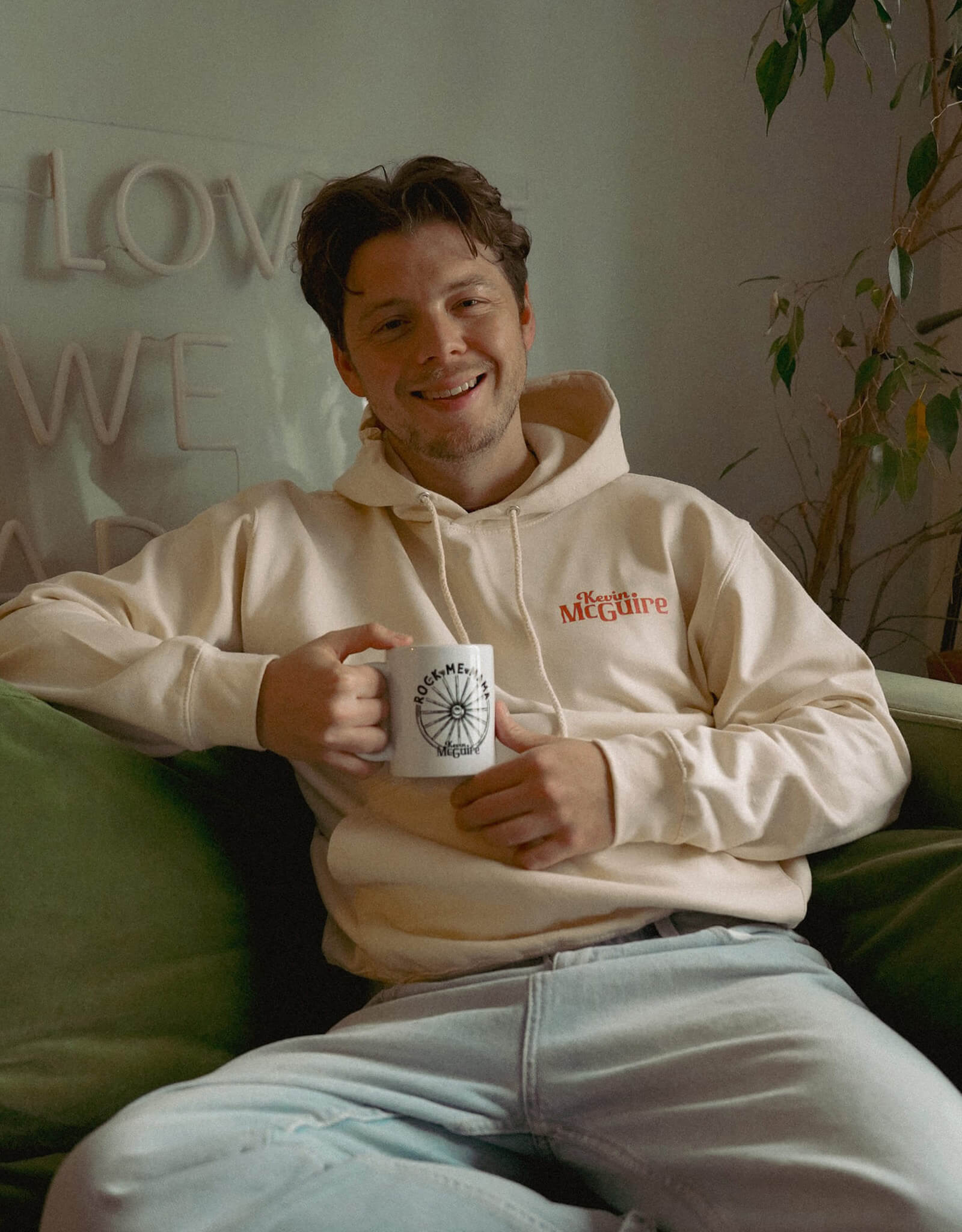 Kevin McGuire wearing his Here We Rodeo hoodie while drinking coffee
